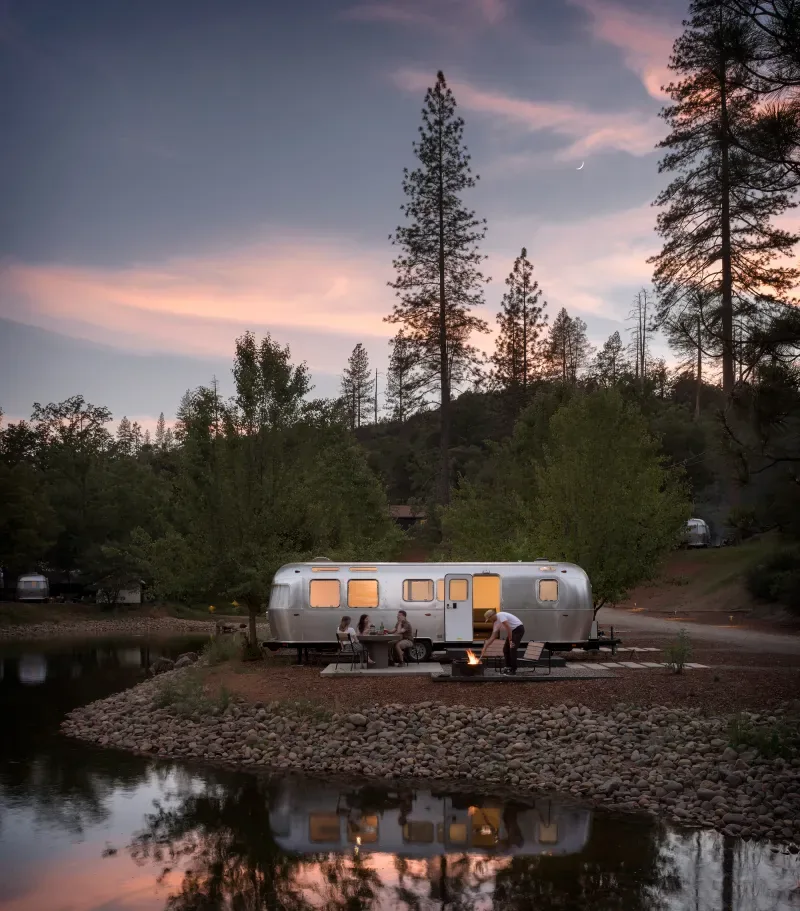 An AutoCamp Airstream by the water at dusk, AutoCamp Yosemite